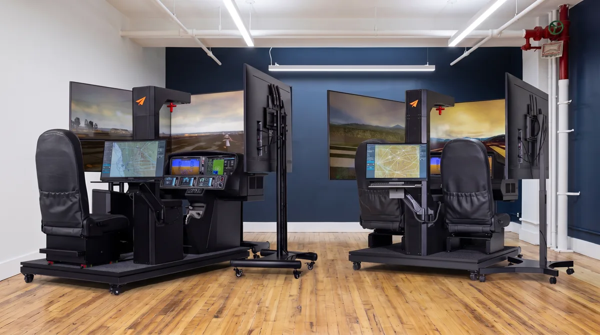 Rendering of the two Cirrus simulators side by side in a navy-walled simulator bay: a single-seat Vision Jet simulator and a two-seat SR-series simulator, each with three flight screens, a lit instrument panel and an instructor monitor